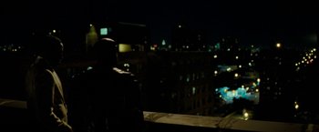 Movie still from “Brooklyn's Finest” (2009), directed by Antoine Fuqua – A man standing on a ledge looking out at a city at night; Wide shot, Over the shoulder angle