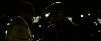 Movie still from “Brooklyn's Finest” (2009), directed by Antoine Fuqua – A man wearing a hat and a leather jacket smiles; Close Up shot, Over the shoulder angle