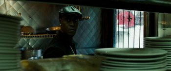 Movie still from “Brooklyn's Finest” (2009), directed by Antoine Fuqua – A man wearing a leather hat in front of plates; Close Up shot, Over the shoulder angle