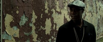Movie still from “Brooklyn's Finest” (2009), directed by Antoine Fuqua – A man wearing a hat standing in front of a wall; Close Up shot, Over the shoulder angle