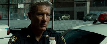 Movie still from “Brooklyn's Finest” (2009), directed by Antoine Fuqua – A man in a police uniform sitting next to a car; Close Up shot, Over the shoulder angle
