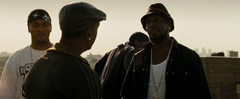 Movie still from “Brooklyn's Finest” (2009), directed by Antoine Fuqua – A man with a hat and a beard talking to another man with a hat; Close Up shot, Over the shoulder angle