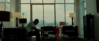 Movie still from “Brooklyn's Finest” (2009), directed by Antoine Fuqua – A man sitting on a couch in front of a large window; Wide shot, High angle