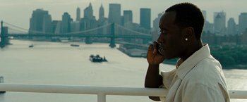 Movie still from “Brooklyn's Finest” (2009), directed by Antoine Fuqua – A man on a cell phone in front of a city skyline; Close Up shot, High angle