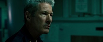 Movie still from “Brooklyn's Finest” (2009), directed by Antoine Fuqua – A person wearing a suit and tie; Close Up shot, Over the shoulder angle