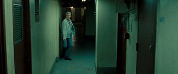 Movie still from “Brooklyn's Finest” (2009), directed by Antoine Fuqua – A man standing in an empty hallway next to a door; Wide shot, High angle