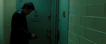 Movie still from “Brooklyn's Finest” (2009), directed by Antoine Fuqua – A man standing next to a door in a room; Medium shot, Low angle