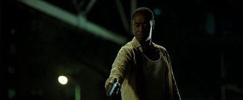 Movie still from “Brooklyn's Finest” (2009), directed by Antoine Fuqua – A man holding a remote in his hand; Close Up shot, Low angle