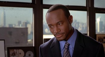Movie still from “Brown Sugar” (2002), directed by Rick Famuyiwa – A man wearing a suit and tie in front of a window; Close Up shot, High angle