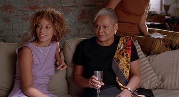 Movie still from “Brown Sugar” (2002), directed by Rick Famuyiwa – Three women are sitting on a couch and one is holding a wine glass; Medium shot, High angle