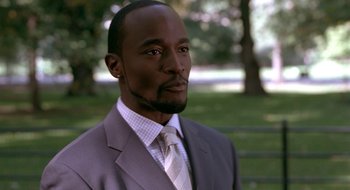 Movie still from “Brown Sugar” (2002), directed by Rick Famuyiwa – A man wearing a suit and tie in a park; Close Up shot, Over the shoulder angle