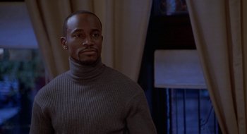 Movie still from “Brown Sugar” (2002), directed by Rick Famuyiwa – A man in a sweater is standing in a room; Close Up shot, Low angle