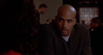 Movie still from “Brown Sugar” (2002), directed by Rick Famuyiwa – A man with a bald head sitting in front of a christmas tree; Close Up shot, Over the shoulder angle
