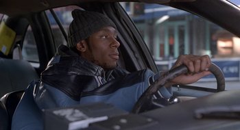 Movie still from “Brown Sugar” (2002), directed by Rick Famuyiwa – A man sitting in the drivers seat of a car; Close Up shot, Over the shoulder angle