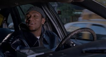 Movie still from “Brown Sugar” (2002), directed by Rick Famuyiwa – A man sitting in the driver's seat of a car; Close Up shot, Low angle