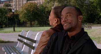 Movie still from “Brown Sugar” (2002), directed by Rick Famuyiwa – A man and a woman sitting on a park bench; Medium shot, Over the shoulder angle