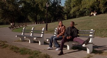 Movie still from “Brown Sugar” (2002), directed by Rick Famuyiwa – Two men sitting on a bench in a park; Wide shot, High angle