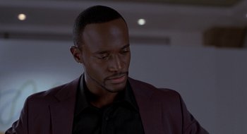 Movie still from “Brown Sugar” (2002), directed by Rick Famuyiwa – A man in a black shirt and a red suit jacket; Close Up shot, Over the shoulder angle
