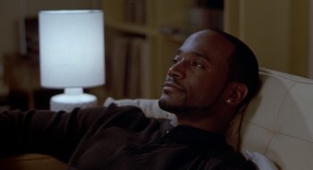 Movie still from “Brown Sugar” (2002), directed by Rick Famuyiwa – A person sitting on a couch; Close Up shot, High angle