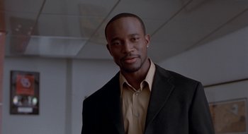 Movie still from “Brown Sugar” (2002), directed by Rick Famuyiwa – A man wearing a suit and a yellow shirt; Close Up shot, Low angle
