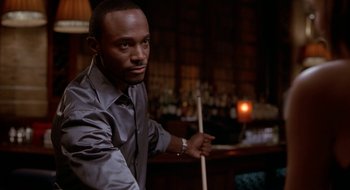 Movie still from “Brown Sugar” (2002), directed by Rick Famuyiwa – A man holding a pool cue in his hand; Close Up shot, Low angle