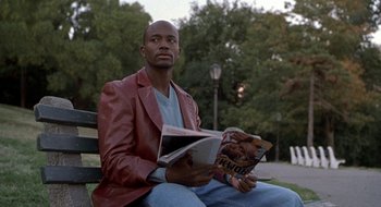 Movie still from “Brown Sugar” (2002), directed by Rick Famuyiwa – A man sitting on top of a wooden bench; Medium shot, High angle