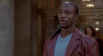 Movie still from “Brown Sugar” (2002), directed by Rick Famuyiwa – A man in a red jacket looking to his left; Close Up shot, Over the shoulder angle
