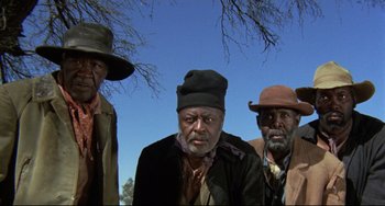 Movie still from “Buck and the Preacher” (1972), directed by Joseph Sargent – A group of men standing next to each other under a blue sky; Medium shot, Low angle