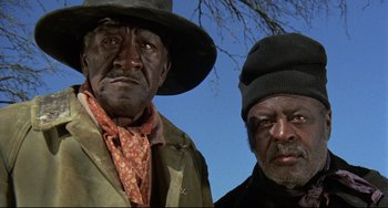 Movie still from “Buck and the Preacher” (1972), directed by Joseph Sargent – Two black men standing next to each other; Close Up shot, Low angle