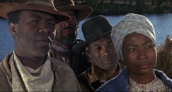 Movie still from “Buck and the Preacher” (1972), directed by Joseph Sargent – A group of men and women standing next to each other; Close Up shot, Low angle