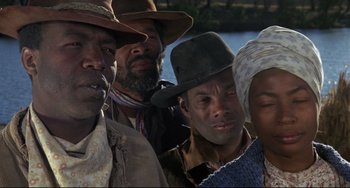 Movie still from “Buck and the Preacher” (1972), directed by Joseph Sargent – A group of people standing next to a body of water; Close Up shot, Low angle