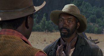 Movie still from “Buck and the Preacher” (1972), directed by Joseph Sargent – A man in a cowboy hat talking to another man in a cowboy hat; Close Up shot, Over the shoulder angle