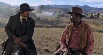Movie still from “Buck and the Preacher” (1972), directed by Joseph Sargent – Two men sitting on a horse in the middle of a field; Medium shot, Over the shoulder angle
