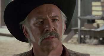 Movie still from “Buck and the Preacher” (1972), directed by Joseph Sargent – An older man with a mustache wearing a cowboy hat; Close Up shot, Over the shoulder angle