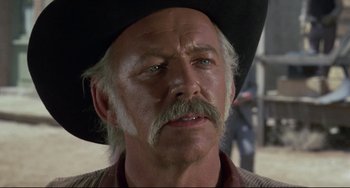 Movie still from “Buck and the Preacher” (1972), directed by Joseph Sargent – An older man with a mustache wearing a cowboy hat; Close Up shot, Over the shoulder angle