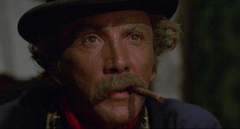 Movie still from “Buck and the Preacher” (1972), directed by Joseph Sargent – A man with a mustache and a hat smoking a cigar; Close Up shot, Low angle