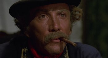 Movie still from “Buck and the Preacher” (1972), directed by Joseph Sargent – A man with a mustache and a cigar in his mouth; Close Up shot, Low angle