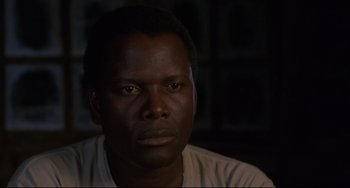 Movie still from “Buck and the Preacher” (1972), directed by Joseph Sargent – A person wearing a white t - shirt; Close Up shot, Over the shoulder angle