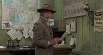 Movie still from “Buck and the Preacher” (1972), directed by Joseph Sargent – An older man in a hat and a brown jacket holding papers; Medium shot, Low angle