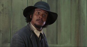 Movie still from “Buck and the Preacher” (1972), directed by Joseph Sargent – A man in a hat and a suit; Close Up shot, Low angle