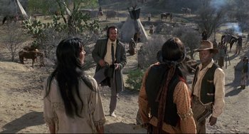 Movie still from “Buck and the Preacher” (1972), directed by Joseph Sargent – A group of people standing on top of a dirt road; Wide shot, Over the shoulder angle