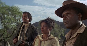 Movie still from “Buck and the Preacher” (1972), directed by Joseph Sargent – A group of people standing next to each other on top of a hill; Medium shot, Low angle