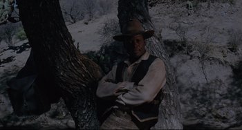 Movie still from “Buck and the Preacher” (1972), directed by Joseph Sargent – A man standing next to a tree in the snow; Medium shot, Low angle