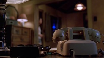 Movie still from “Bug” (2006), directed by William Friedkin – An old phone sitting on top of a wooden table; Extreme Close Up shot, Low angle