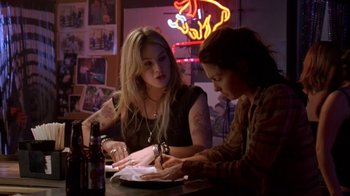 Movie still from “Bug” (2006), directed by William Friedkin – Two women sitting at a table in front of a neon sign; Medium shot, Over the shoulder angle