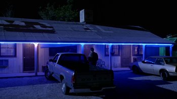 Movie still from “Bug” (2006), directed by William Friedkin – A man sitting in the back of a pick - up truck at night; Wide shot, Low angle