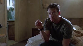 Movie still from “Bug” (2006), directed by William Friedkin – A man sitting on the ground in a room; Medium shot, Low angle
