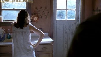 Movie still from “Bug” (2006), directed by William Friedkin – A woman standing in front of a sink in a room; Medium shot, Over the shoulder angle