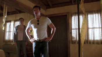 Movie still from “Bug” (2006), directed by William Friedkin – A man standing in front of a woman in front of a door; Medium shot, Low angle