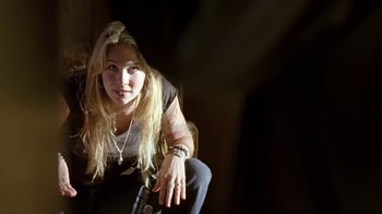 Movie still from “Bug” (2006), directed by William Friedkin – A woman sitting on the ground in a dark room; Close Up shot, Over the shoulder angle